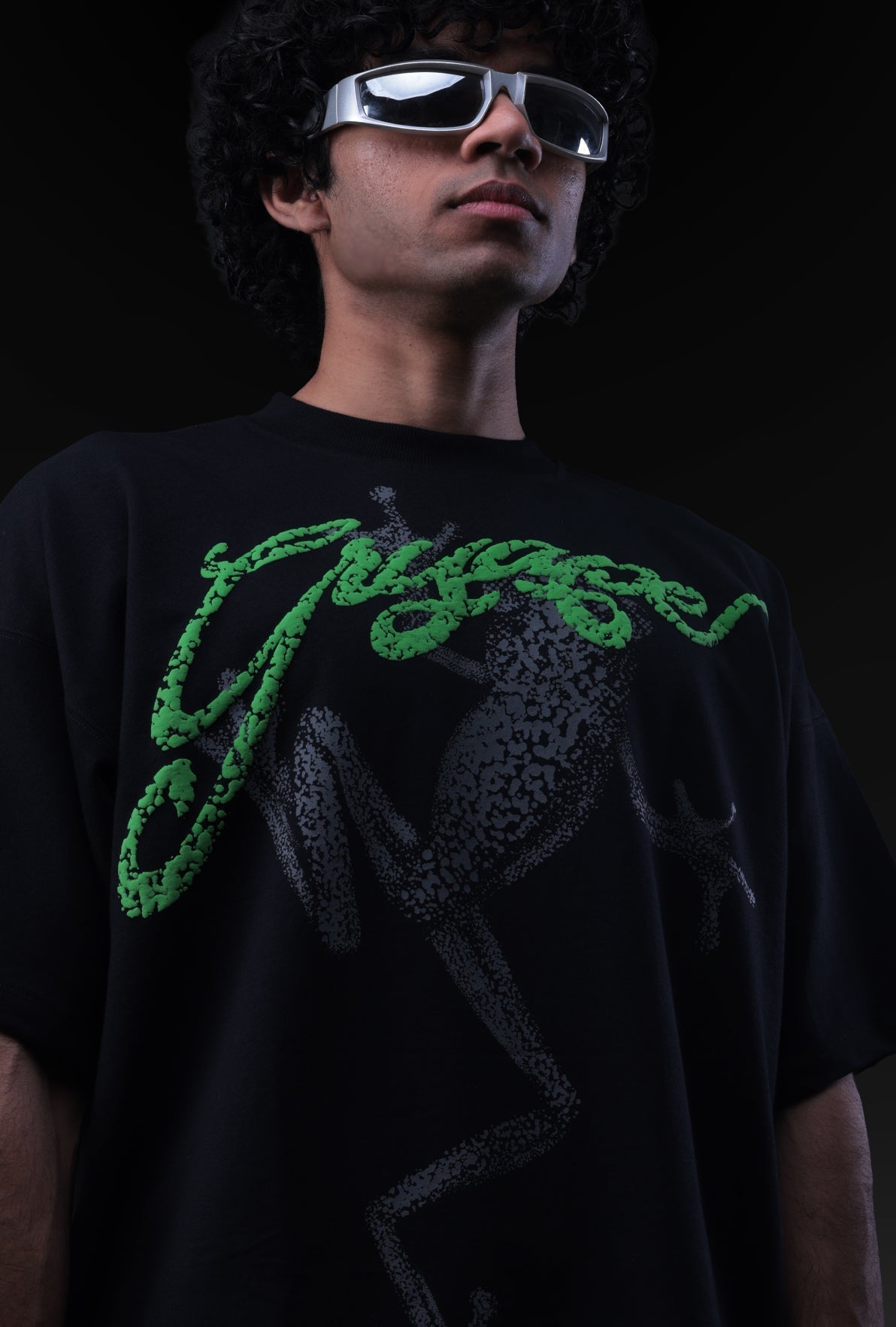 Person wearing a black t-shirt with green text and sunglasses against a dark background Crepdog Crew