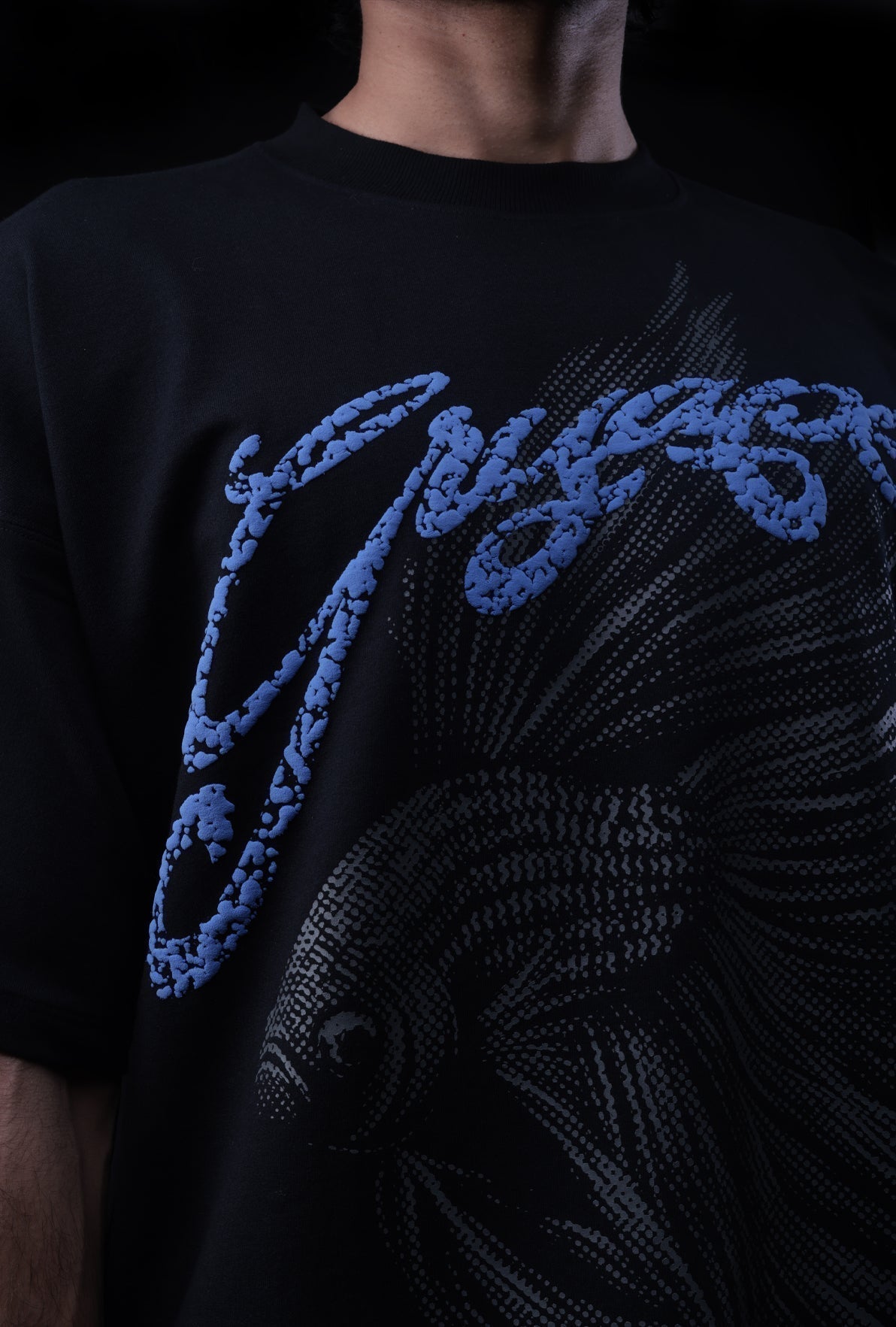Black t-shirt with blue graphic design on a dark background Crepdog Crew