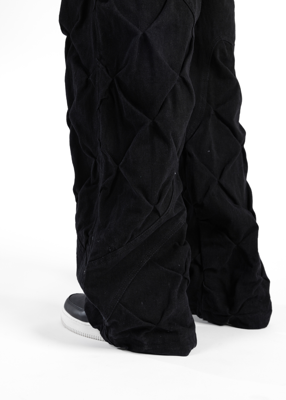 Black quilted pants on a white background