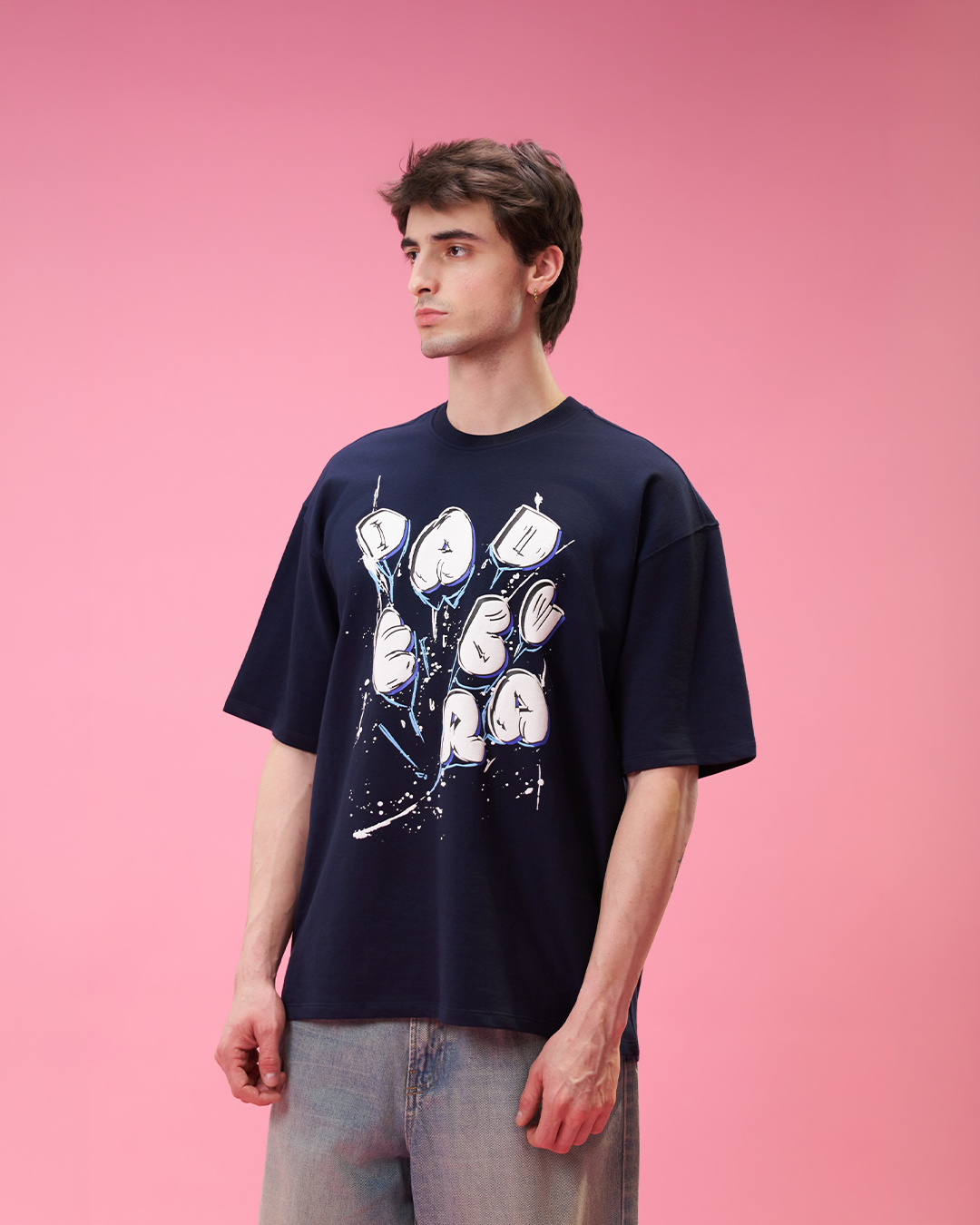 Person wearing a navy blue t-shirt with graphic design on a pink background Crepdog Crew