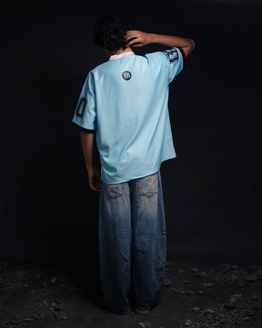 Person wearing a light blue sports jersey with dark sleeves against a black background - Crepdog Crew