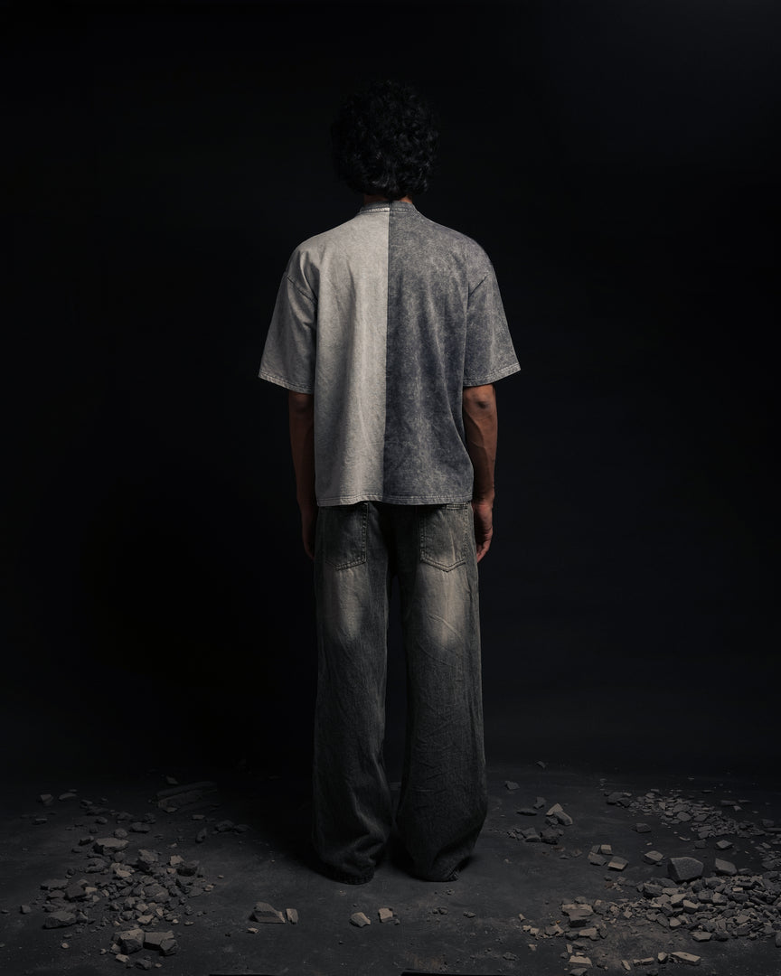 Person wearing a gray t-shirt and dark pants standing in a dark, rocky environment - Crepdog Crew