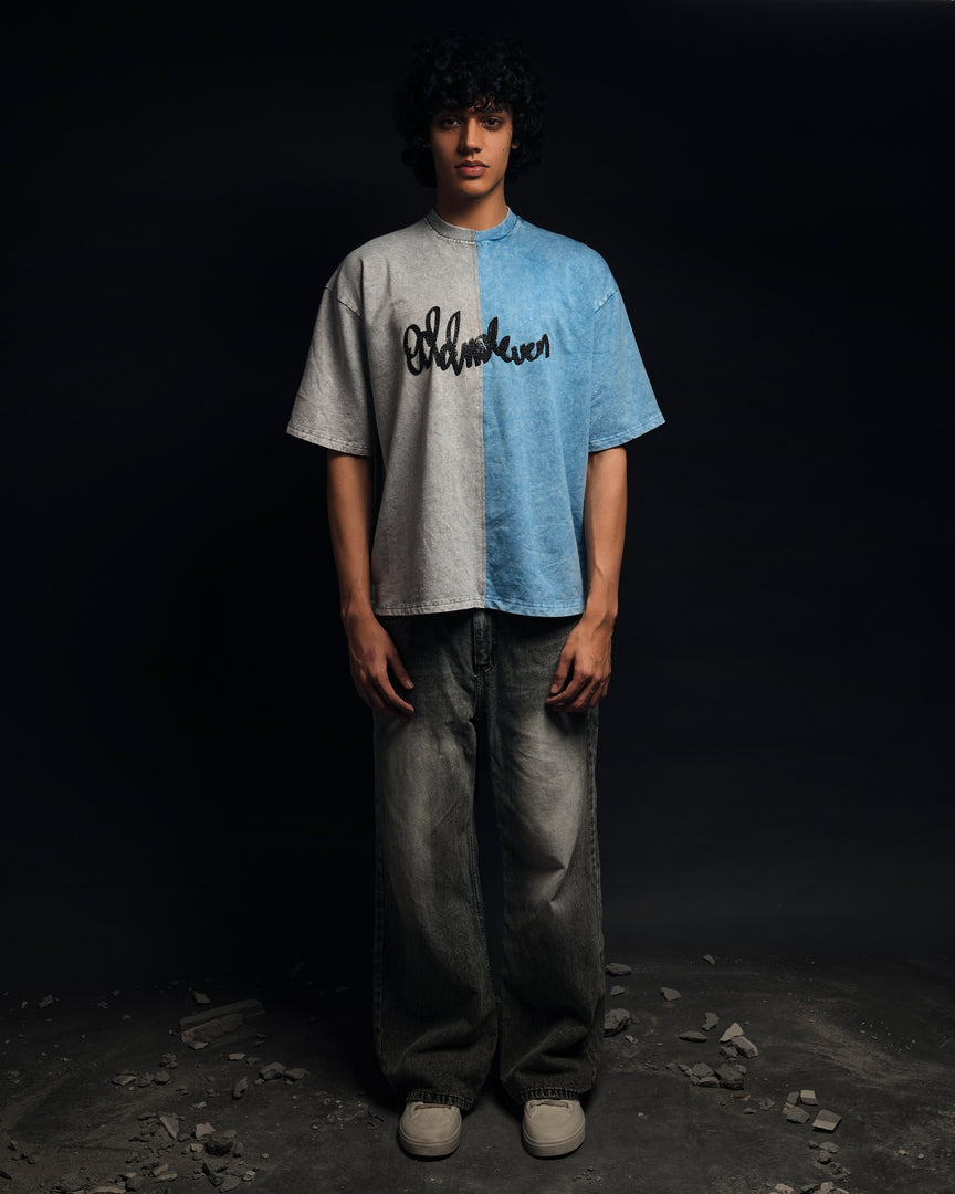Person wearing a two-tone shirt with text, standing against a dark background - Crepdog Crew