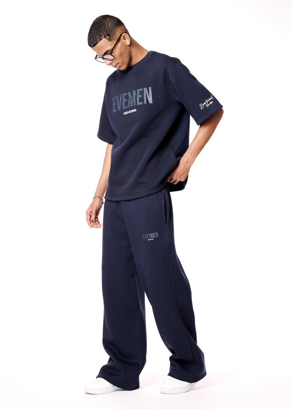 Man wearing navy blue 'EVEN' t-shirt and pants on a white background