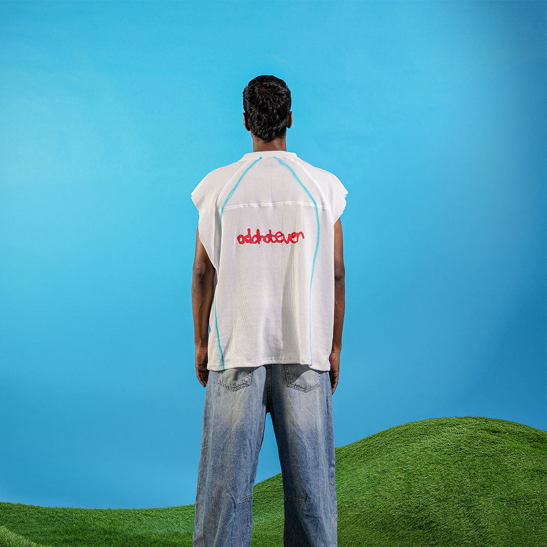 Person wearing a sleeveless shirt with 'oldhoney' logo against a blue sky and green landscape Crepdog Crew