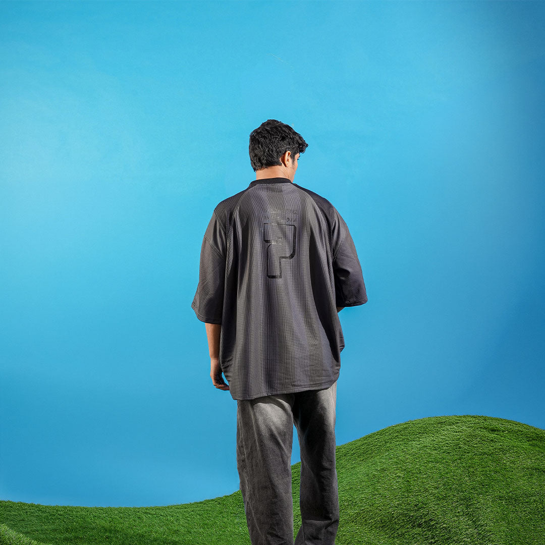 Person wearing a dark outfit standing on a grassy hill with a blue sky background Crepdog Crew