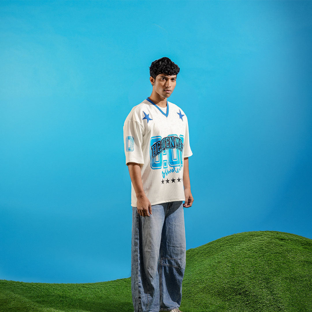 Person wearing a sports jersey on a grassy hill with blue sky background Crepdog Crew