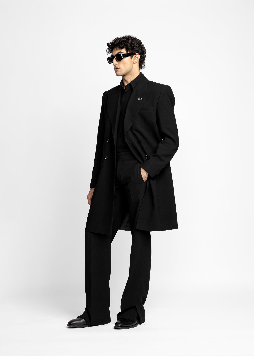Man wearing a black coat and sunglasses on a white background - Crepdog Crew