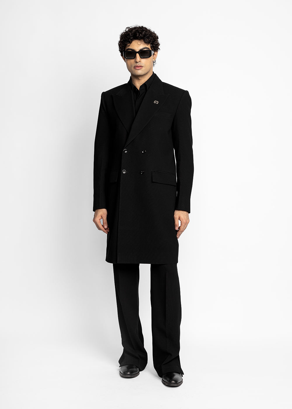 Man wearing a black coat and sunglasses on a white background - Crepdog Crew