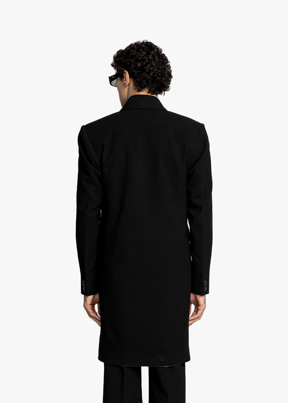 Person wearing a black coat from behind on a white background - Crepdog Crew