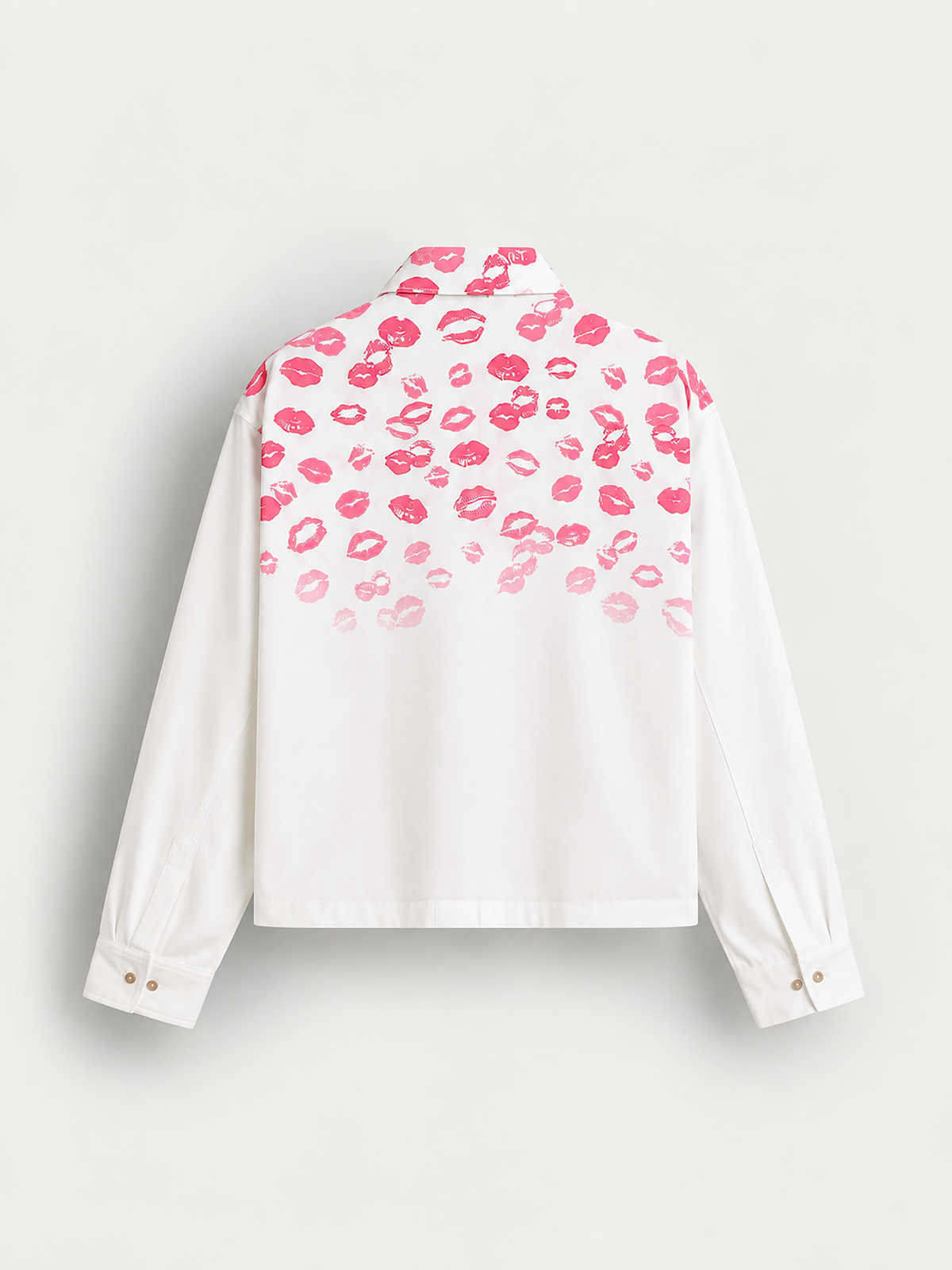 A white long-sleeve button-up shirt shown from the back, featuring a pink lip print pattern concentrated across the upper back and shoulders, fading lighter toward the lower back, on a light gray background.