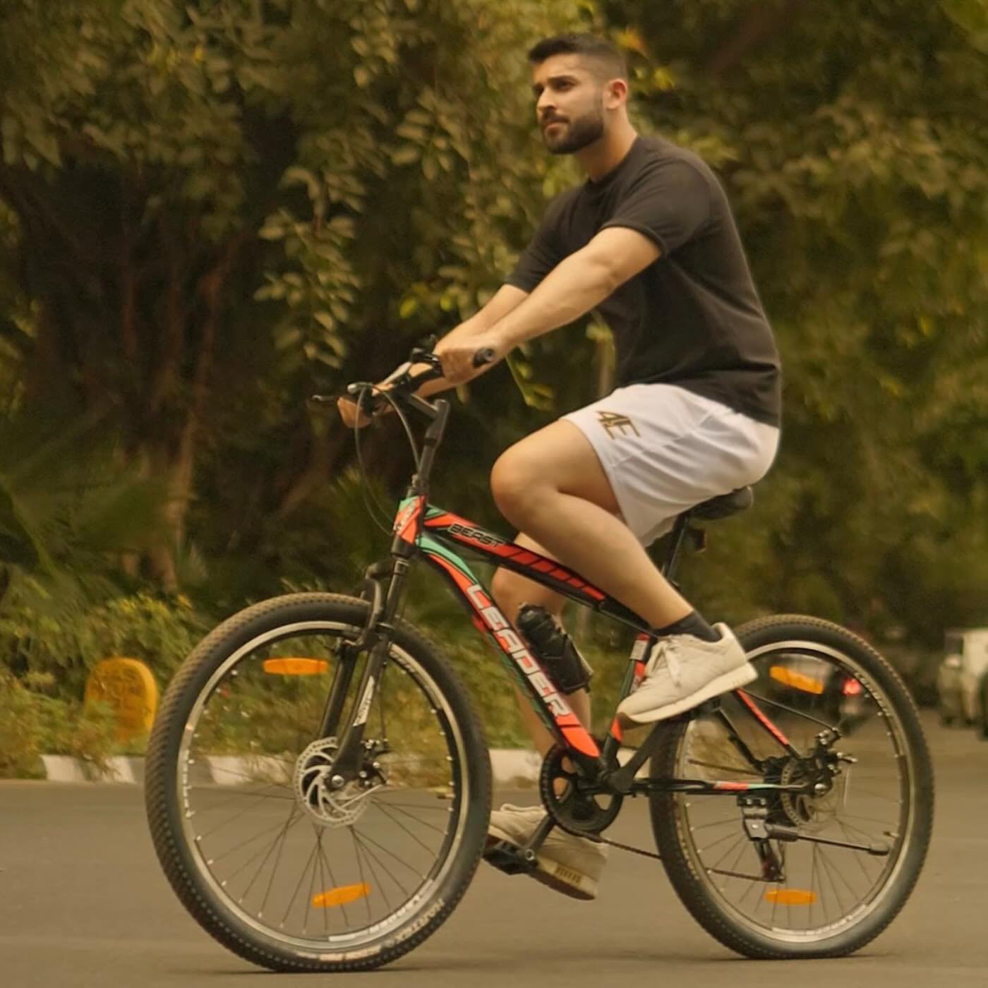 Man riding a bicycle on a road with greenery in the background - Crepdog Crew