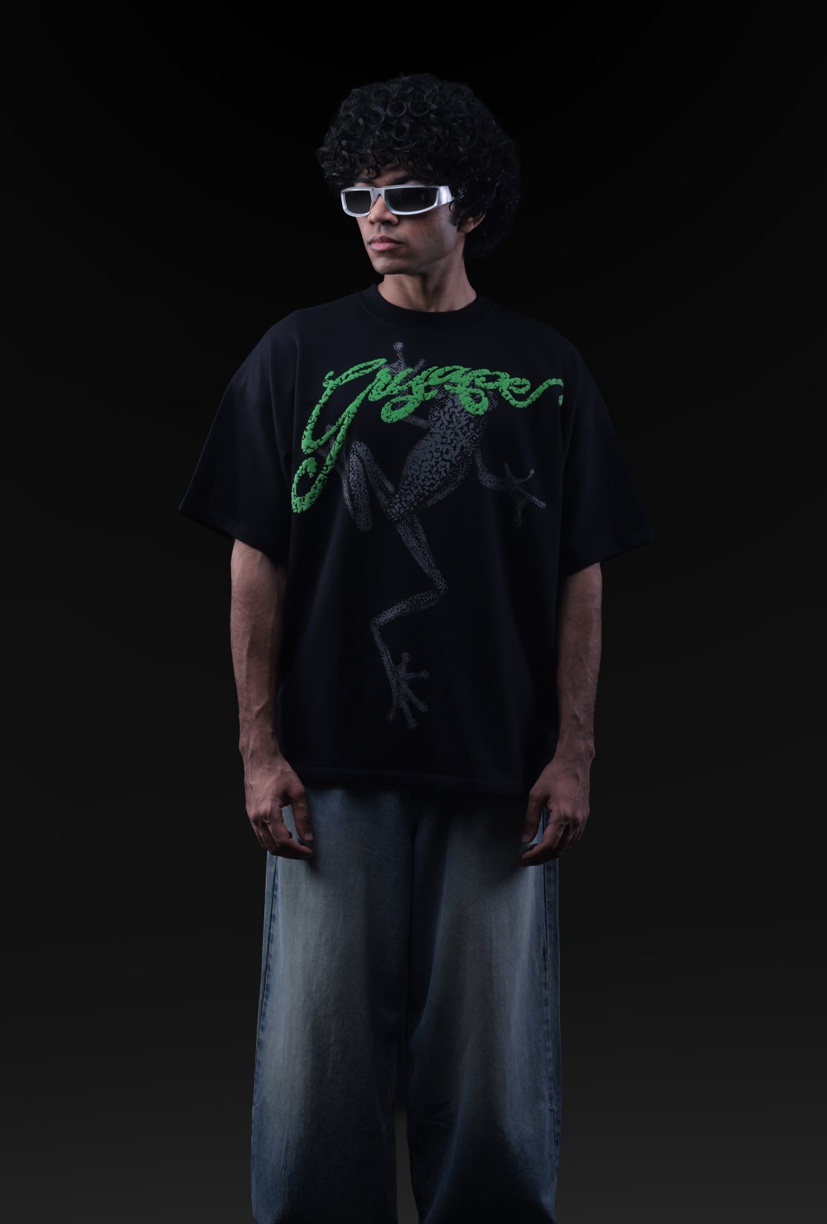 Person wearing a black t-shirt with green text and sunglasses on a black background Crepdog Crew