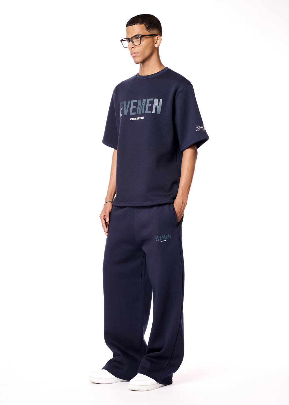 Man wearing a navy blue 'EVENEM' t-shirt and pants on a white background