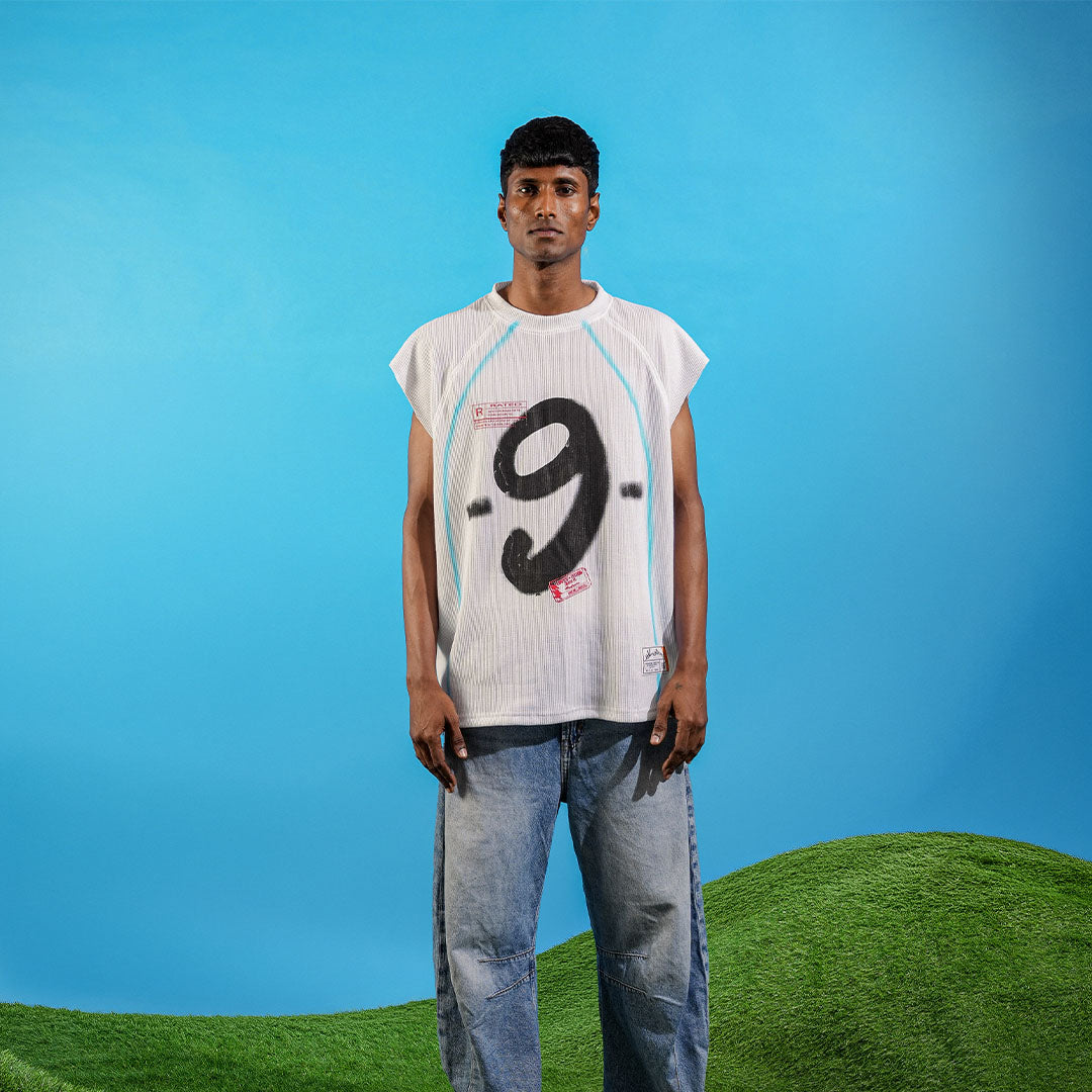 Person wearing a white sleeveless shirt with a black number 9 on a blue and green landscape background Crepdog Crew