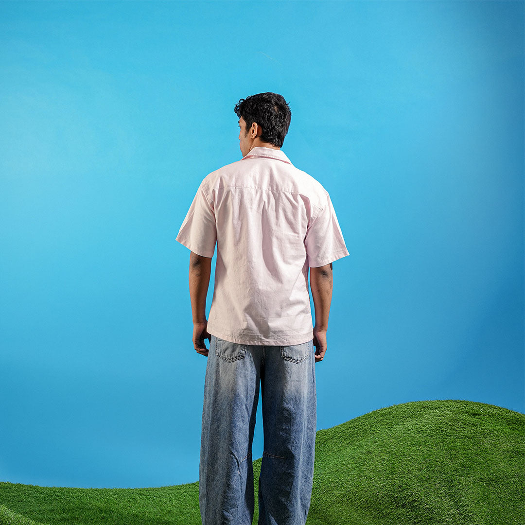Man standing on a grassy hill with a clear blue sky Crepdog Crew