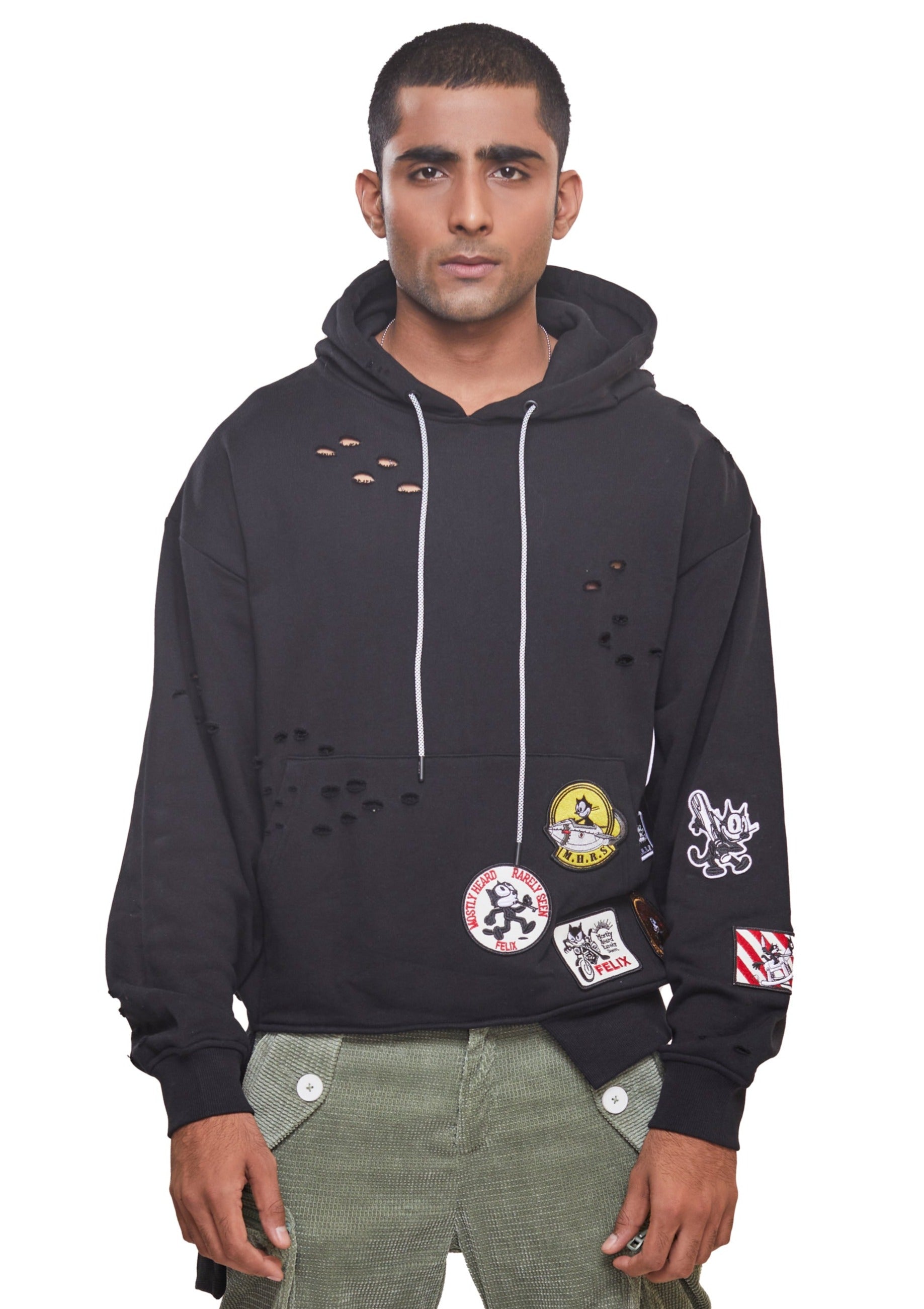 Black cotton drop shoulder hoodie with logo patch to the front, punched holes, asymmetric hem and drawstrings with long sleeves and fitted-cuff sleeves from the brand Mostly Heard Rarely Seen