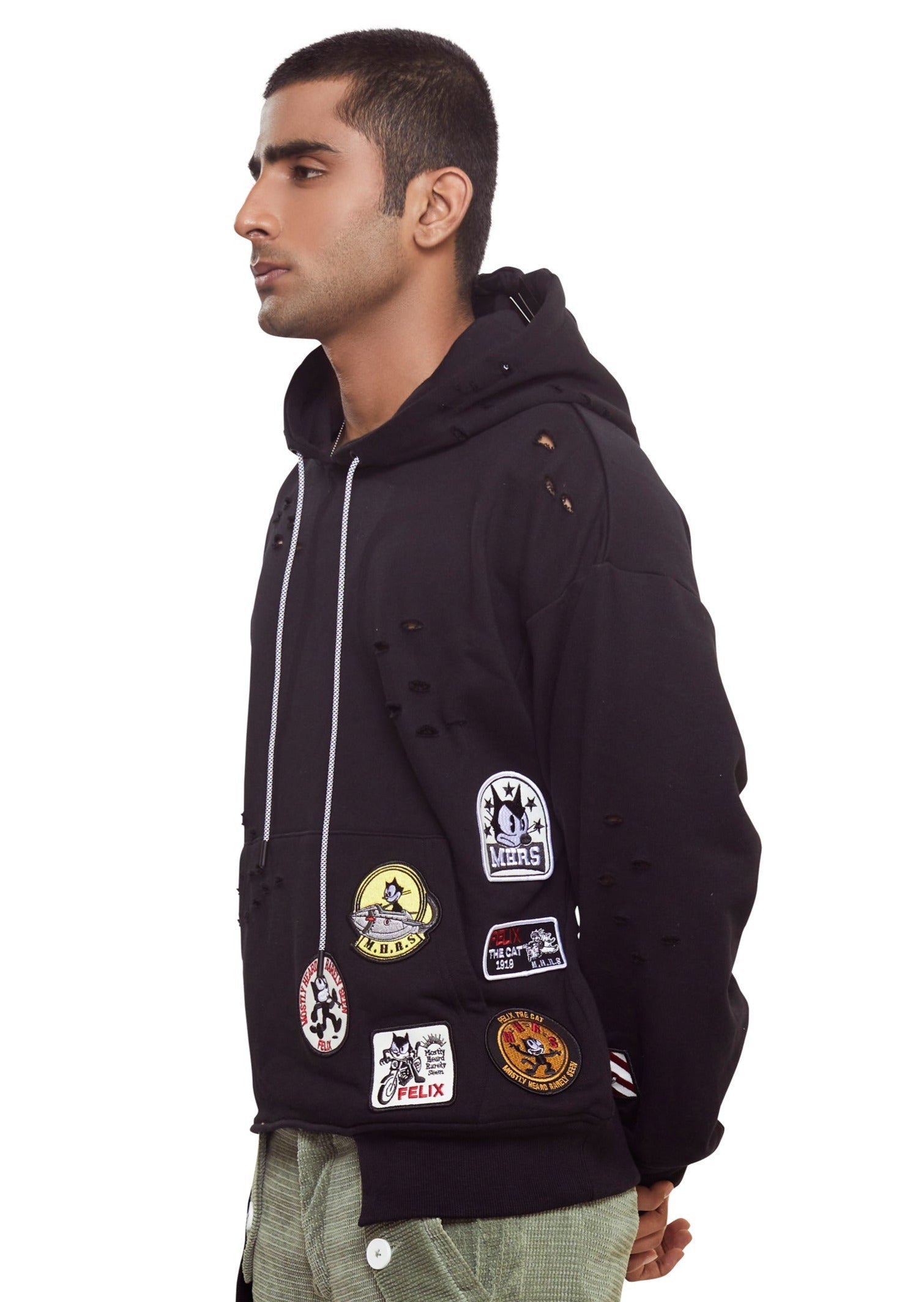 Black cotton drop shoulder hoodie with logo patch to the front, punched holes, asymmetric hem and drawstrings with long sleeves and fitted-cuff sleeves from the brand Mostly Heard Rarely Seen